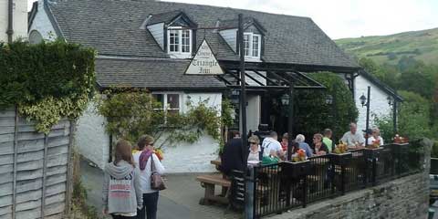 Guests enjoying lunch outside the Triangle Inn with pretty views of the surrounding countryside